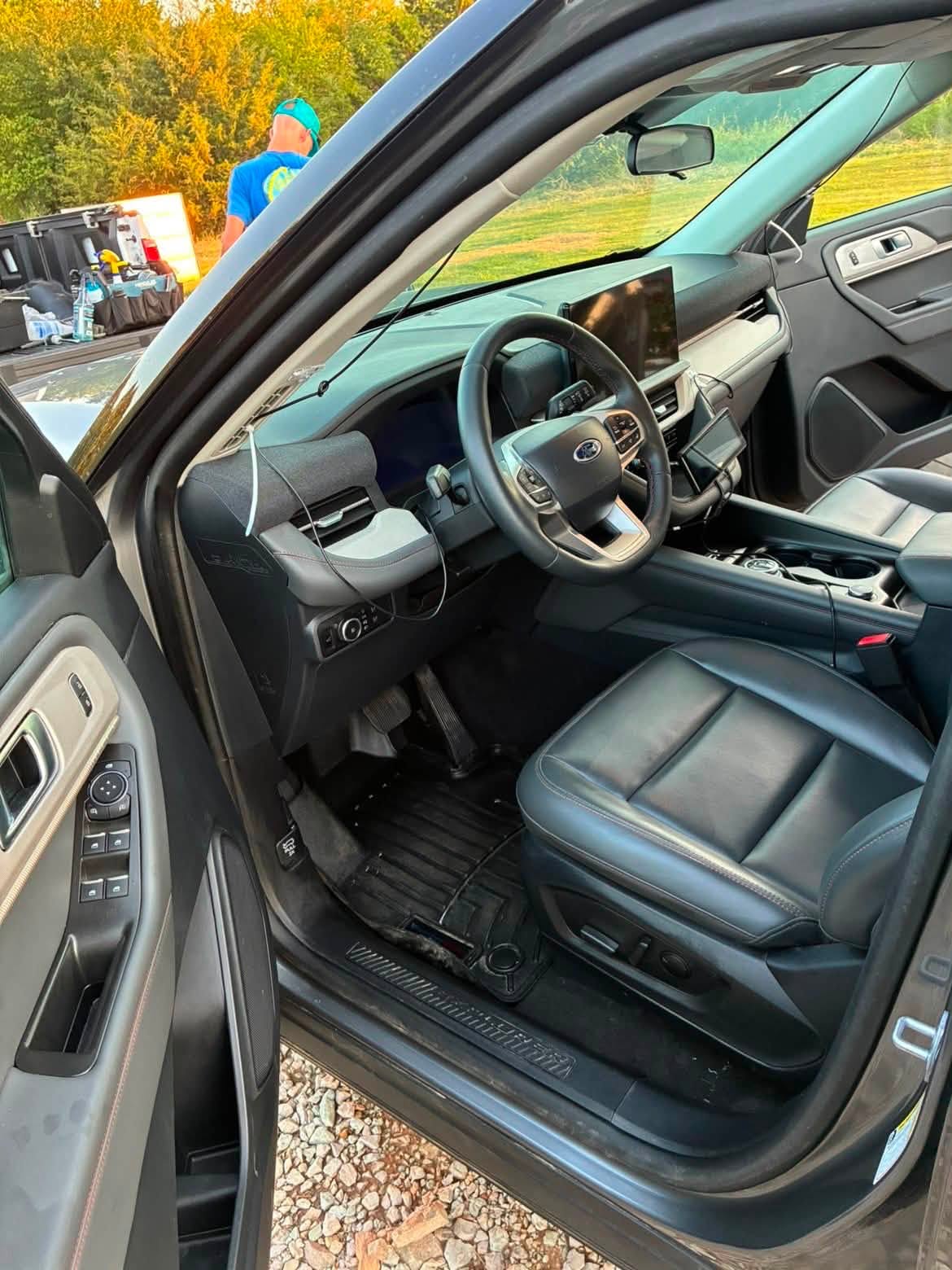 Same Ford Explorer driver area after interior detailing, with clean leather seat, dash and floor mat