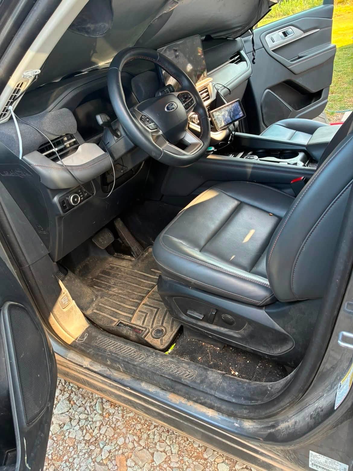 Ford Explorer driver area before detailing, with dirt on the door sill, floor mat and console in Prague, OK
