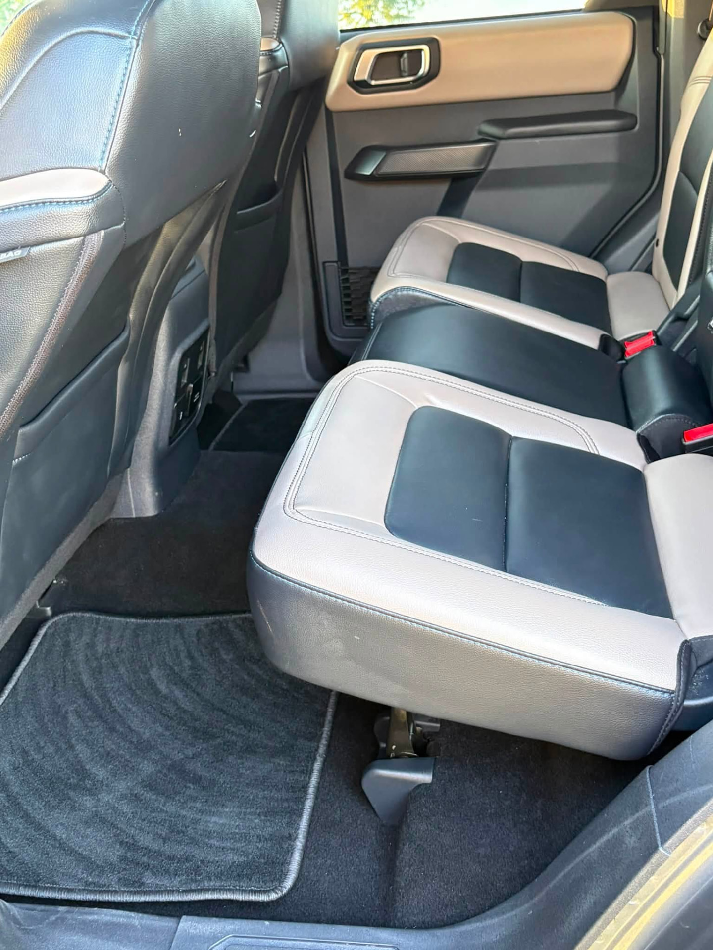 Ford Bronco second row after detailing, with clean leather seats, vacuumed carpet and fresh floor mats