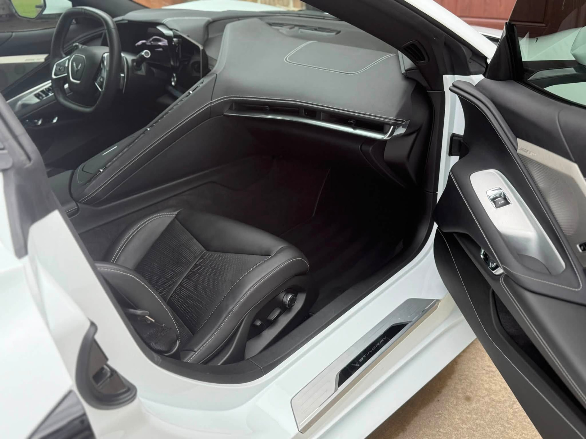 Passenger side of a detailed C8 Corvette interior with clean leather seat, dash and carpet